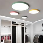 Marden round LED flush mount ceiling light in green, pink, yellow and grey on a white ceiling