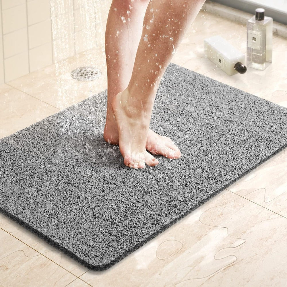 Milton non slip grey loop shower mat on a bathroom floor with water draining through