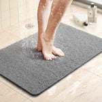 Milton non slip grey loop shower mat on a bathroom floor with water draining through