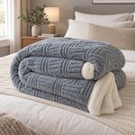 Dalton reversible knitted throw blanket in grey folded on a bed