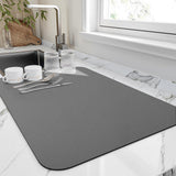 Ashton grey diatomite dish drying mat on a marble kitchen worktop beside the sink