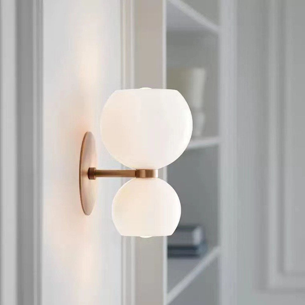 Ridley double glass globe wall light with opal shades mounted on a pale wall