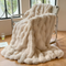 Halstead faux fur fleece throw blanket draped over a bed with soft neutral bedding